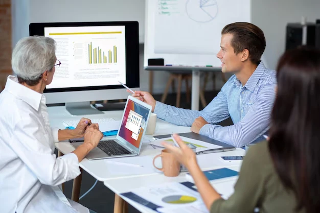 People-discussing-charts-laptops-in-office-meeting