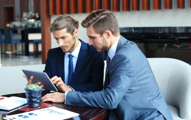 two-businessmen-watching-SEO-strategy-using-tablet-in-modern-office-setting