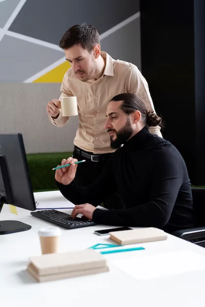 two-marketers-working-on-ugc-strategy-in-office-with-computer-and-coffee
